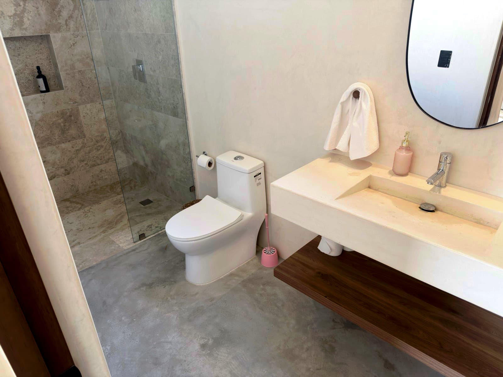 Freshly cleaned bathroom with a walk-in glass shower and a floating stone vanity in Norcross