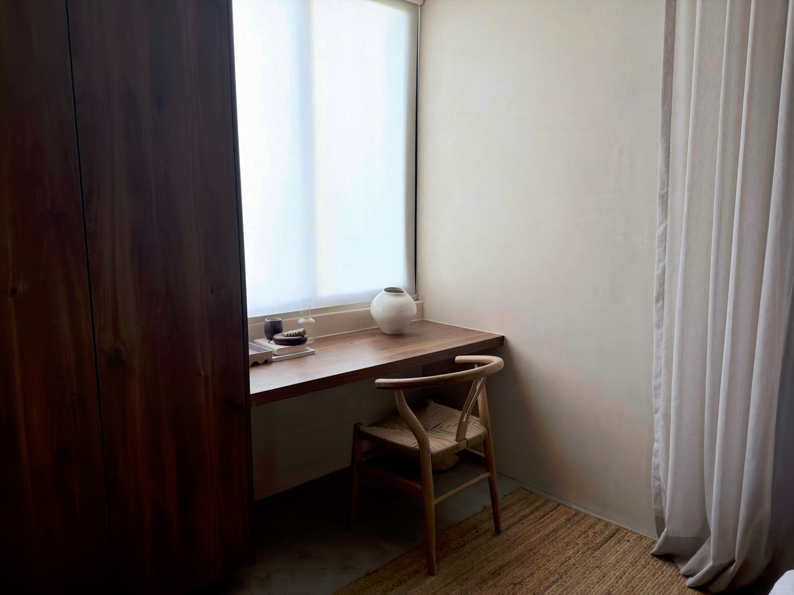 Freshly cleaned bedroom study nook with a built-in desk and a wishbone chair in Lawrenceville