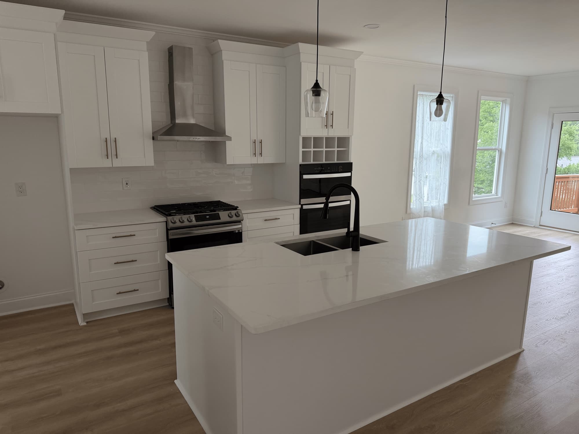 Freshly cleaned kitchen with white shaker cabinets and a marble island