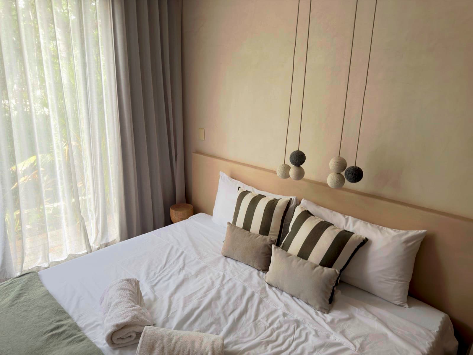 Freshly cleaned primary bedroom with crisp white linens and sheer curtains in Lawrenceville