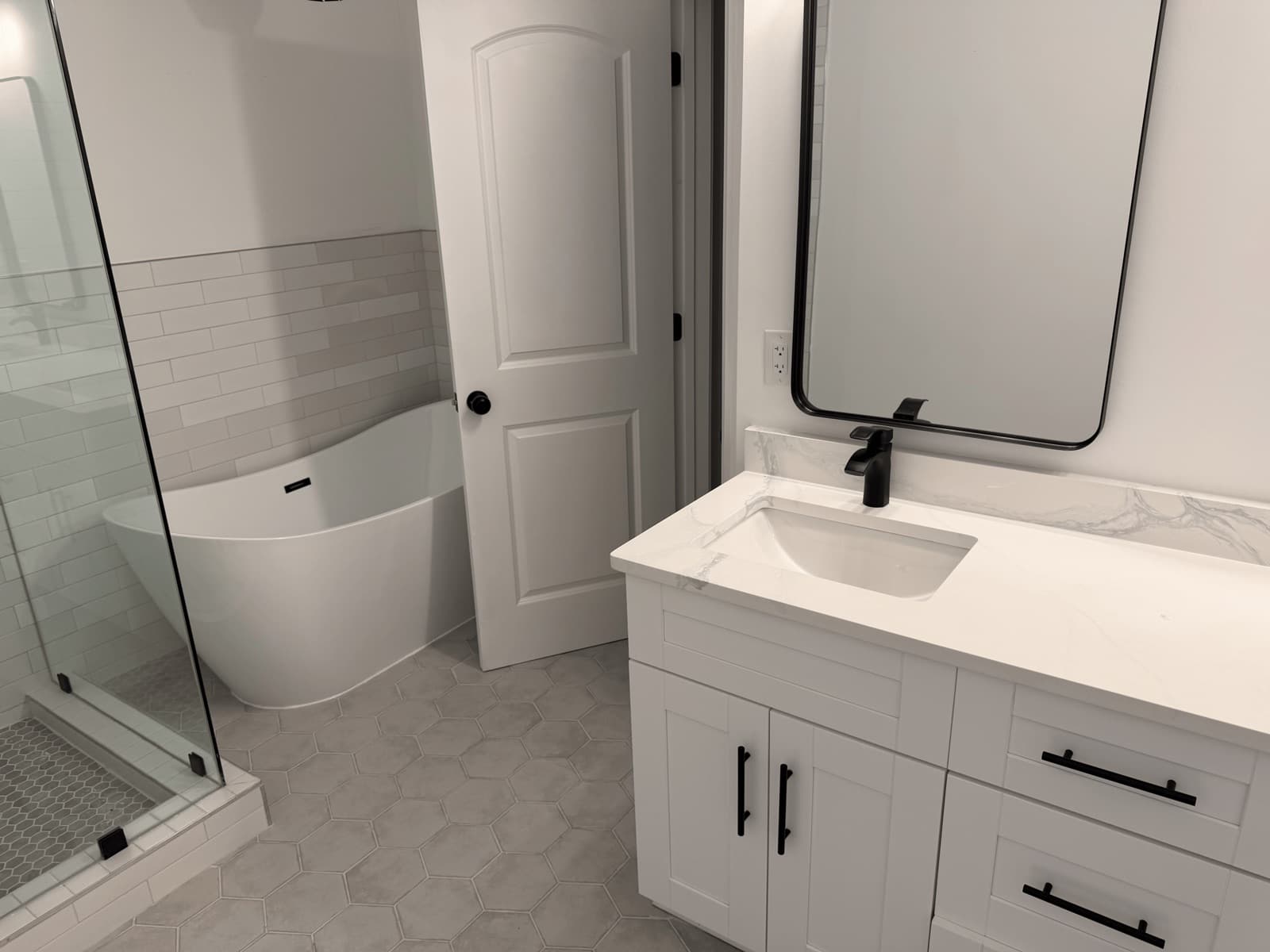Empty bathroom with a freestanding tub and glass shower after a move-out clean